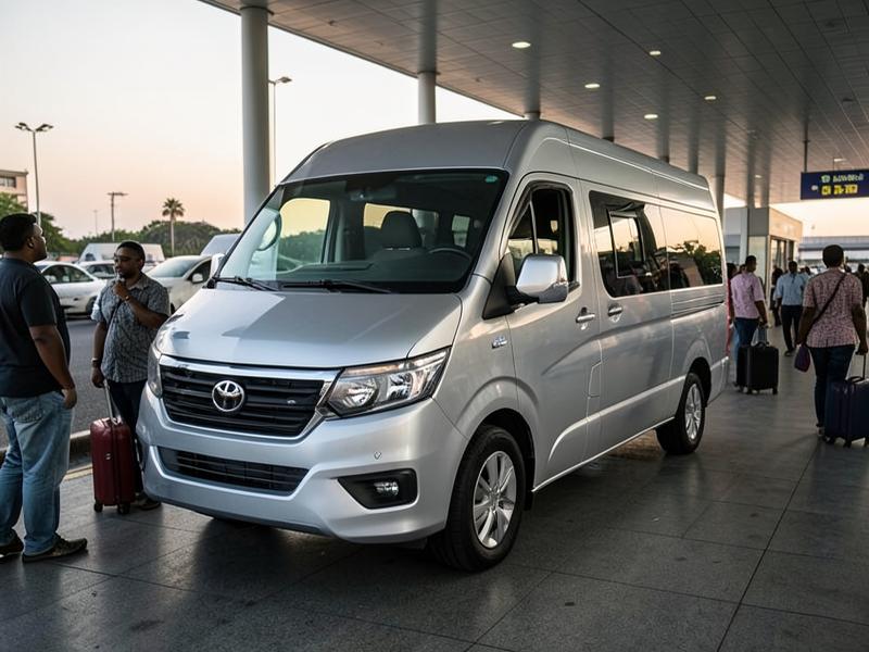 A passenger van at an airport terminal with travellers and suitcases