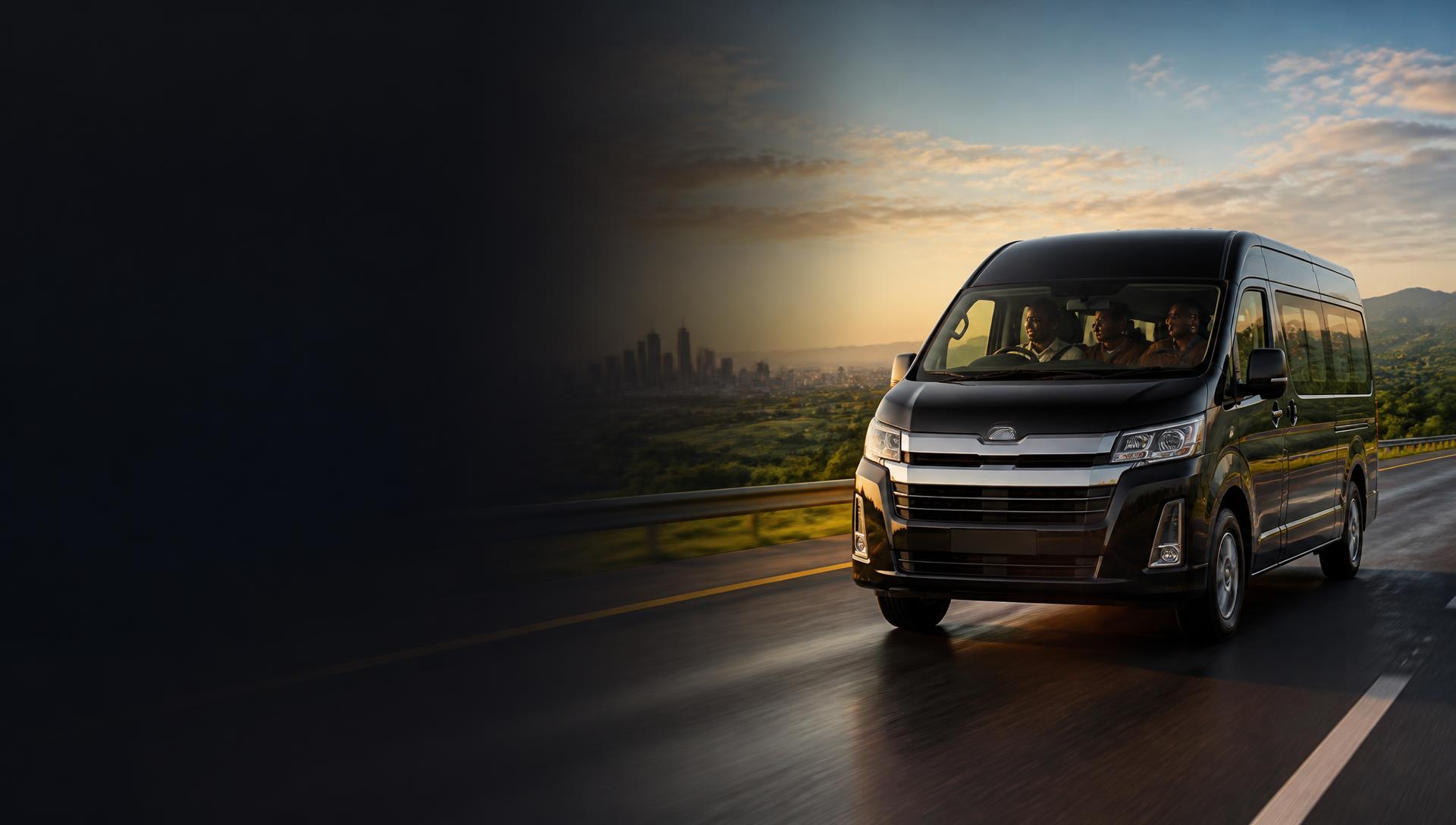 A premium black passenger van carrying travellers along a Kenyan highway from the Nairobi skyline toward green countryside and distant mountains at golden hour